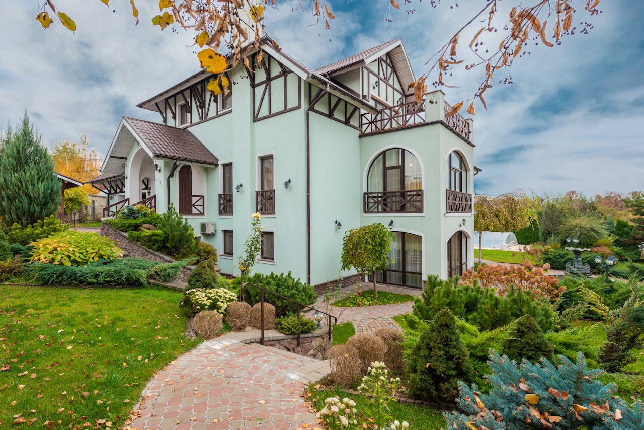 House surrounded by an autumn garden, ready for early home heating preparation. Image via Pexels