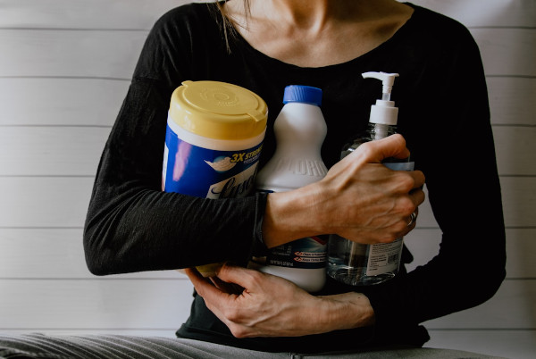 Person holding cleaning supplies