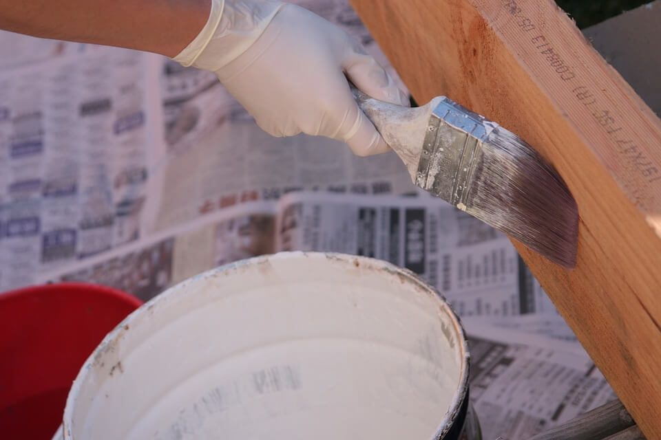 Person drilling into wood next to a window