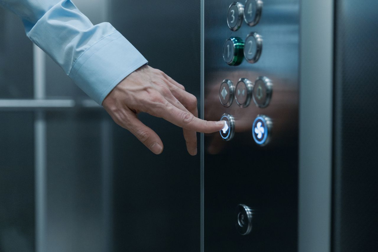 Close-up shot of a hand pressing an elevator button. Image by Pexels