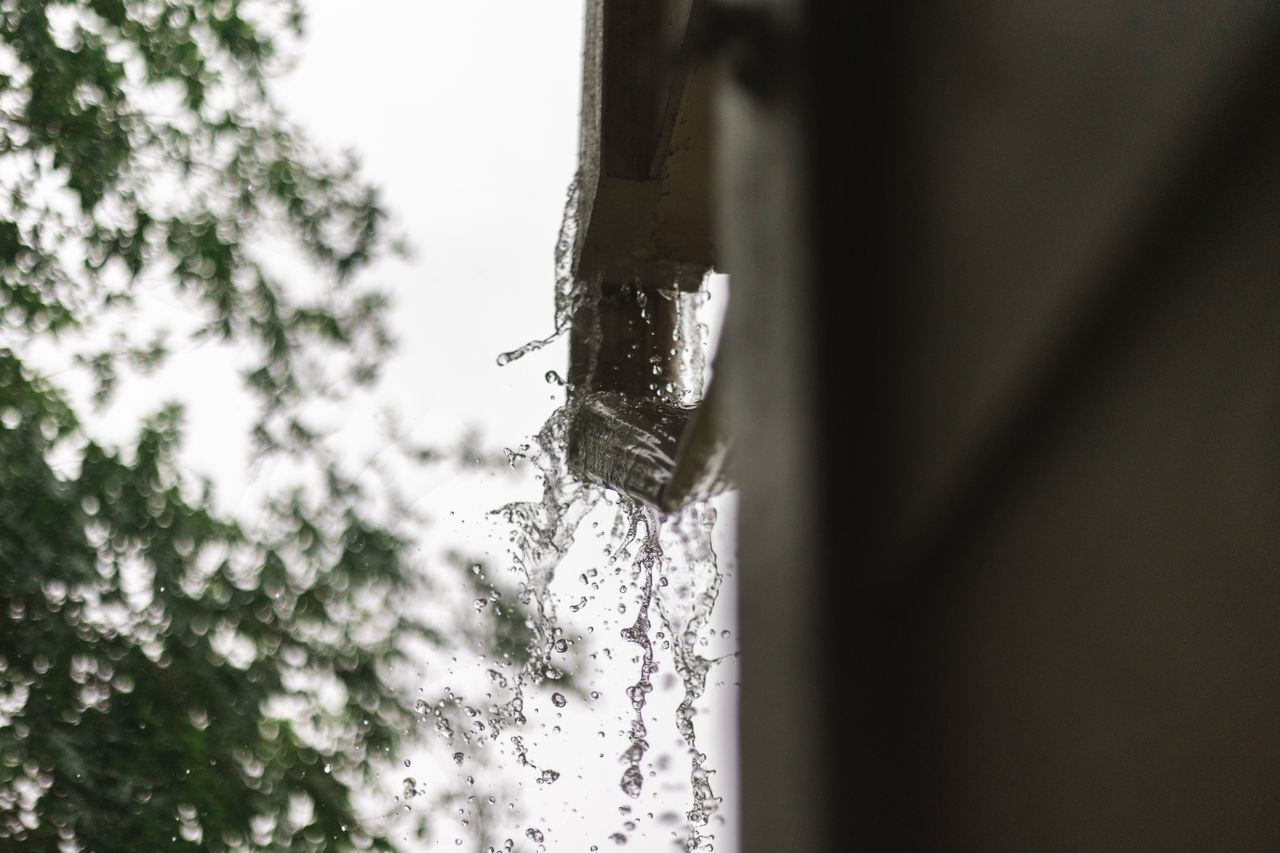 Rain water flowing through a gutter on a Boston home illustrating the role of proper drainage in protecting the building. Photo by Devin Brown on Pexels