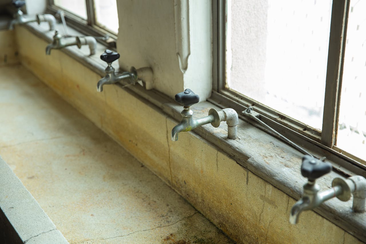 old taps above public sink in a buidling. Image by Pexels