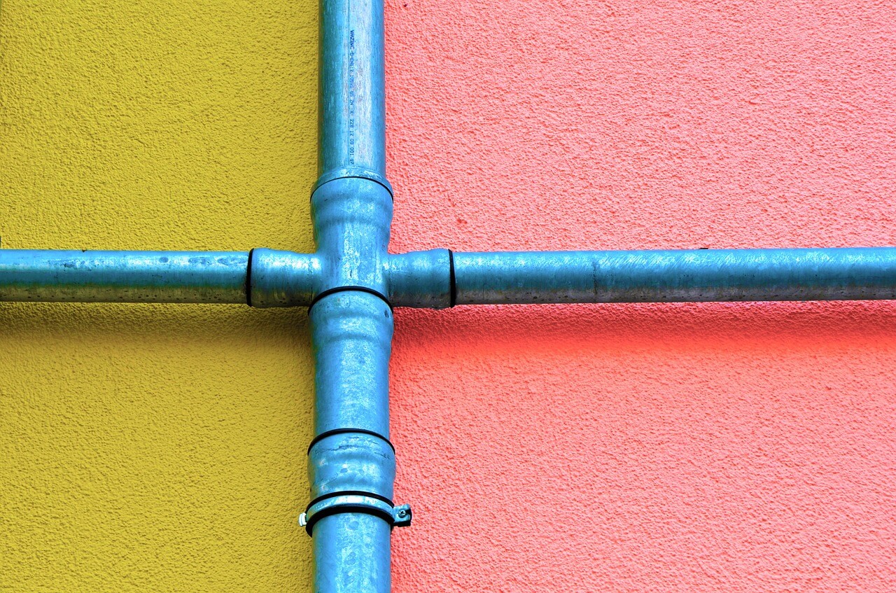 blue colored pipes on pink and yellow ground. Image by Pixabay