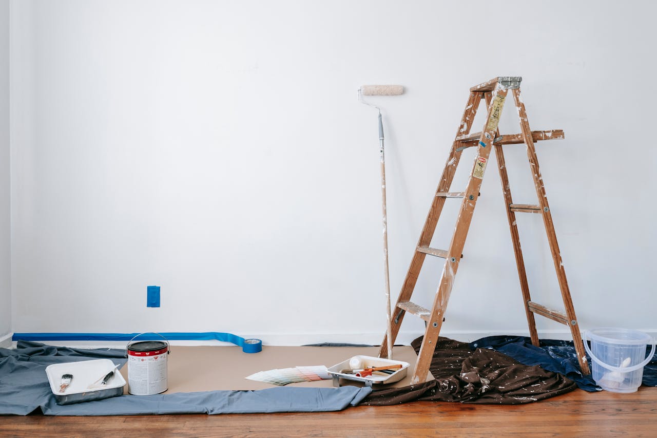 Wooden ladder besides painting materials. Image by Pexels