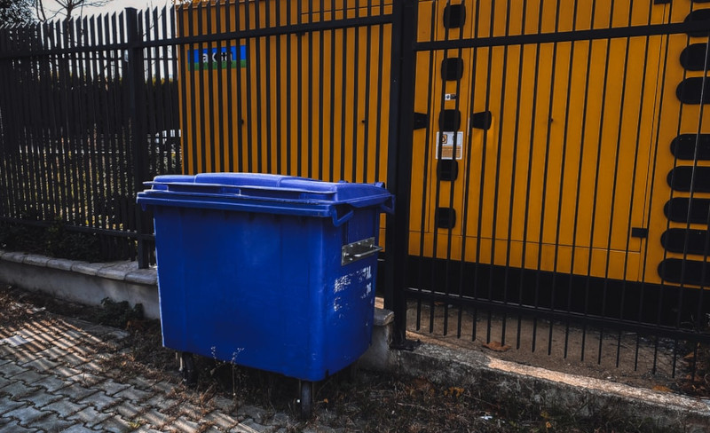 Dumpster in front of a gate