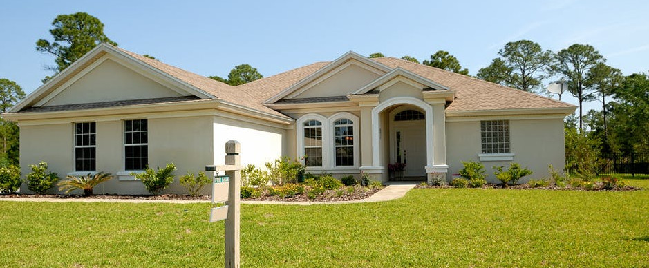 house with a for sale sign on the lawn