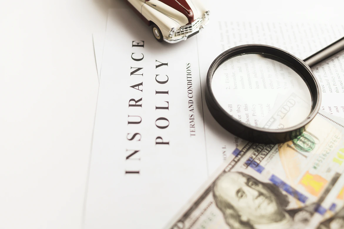 insurance policy paper, money, magnifying glas
