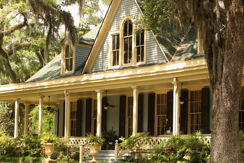 Light green house with a large front porch