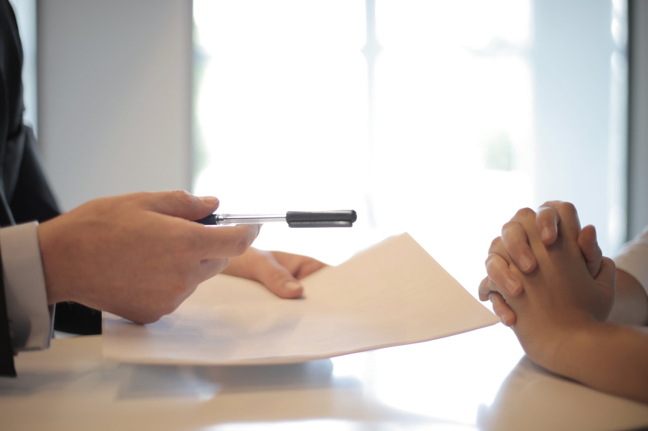 person holding a pen and paper