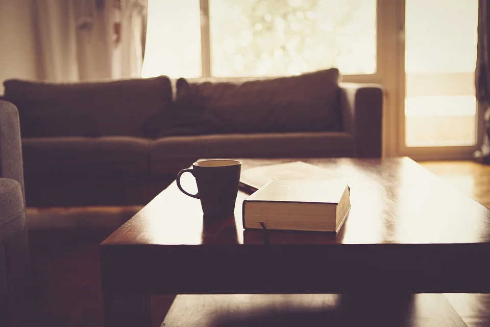 Sofa, table with book and mug