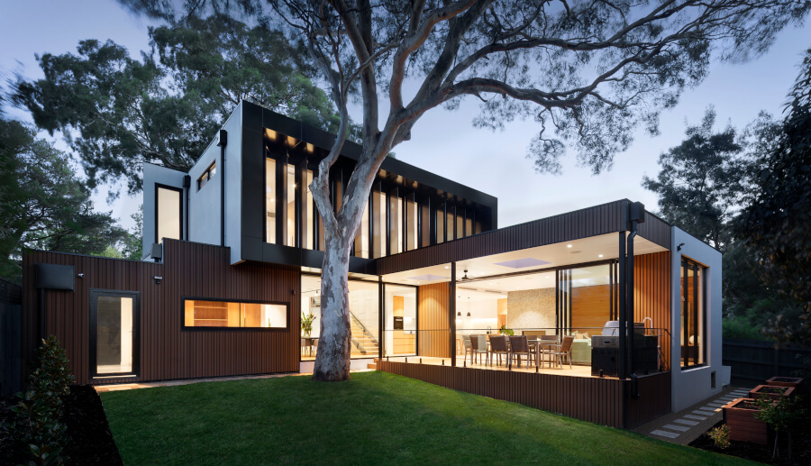 house with lots of windows, lit up at night