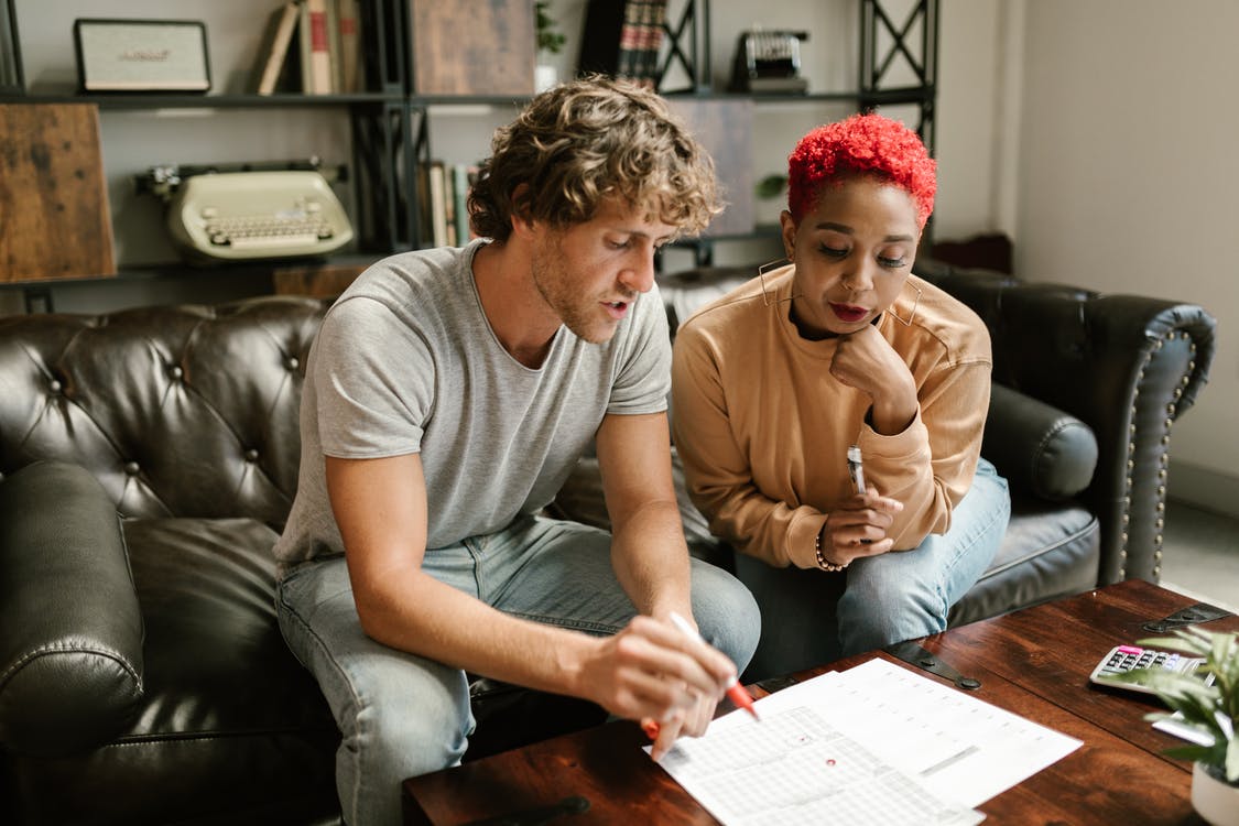 2 people sitting down looking at paperwork