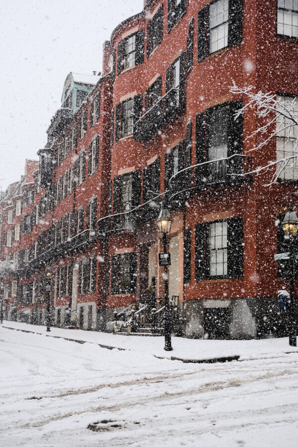 snow falling outside a brick building