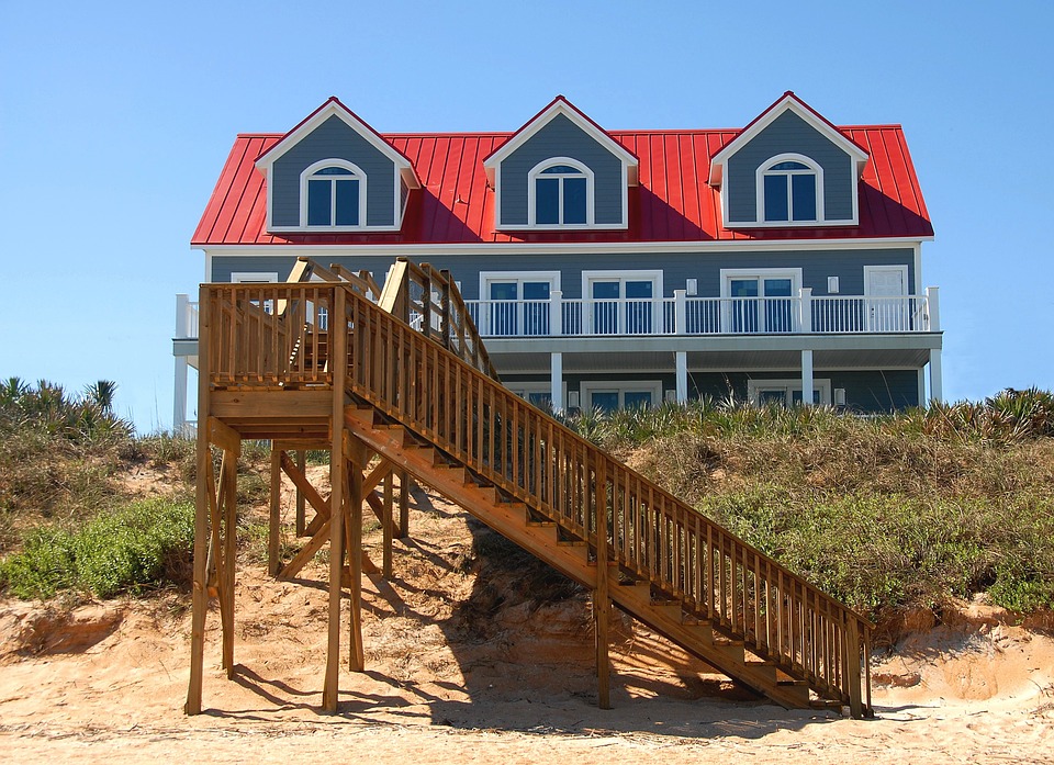 Bluw house with red roof on a beach