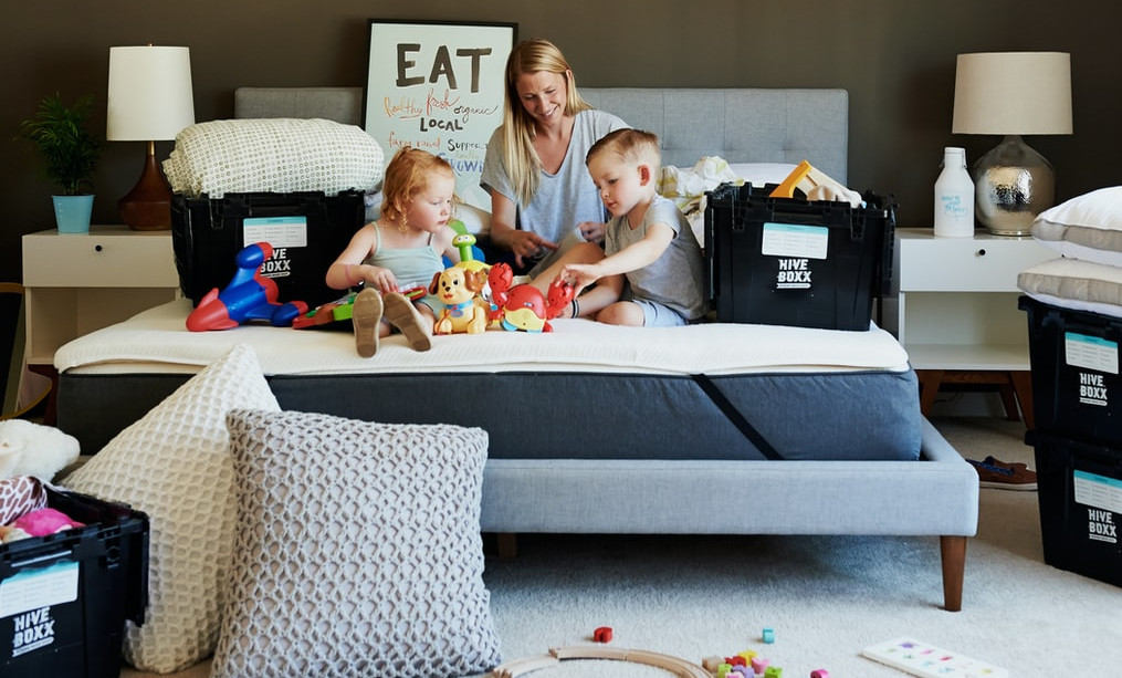 3 people playing on a bed