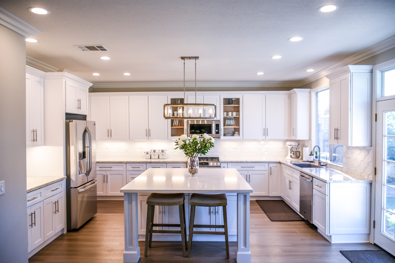 Modern, white kitchen with stainless appliances.