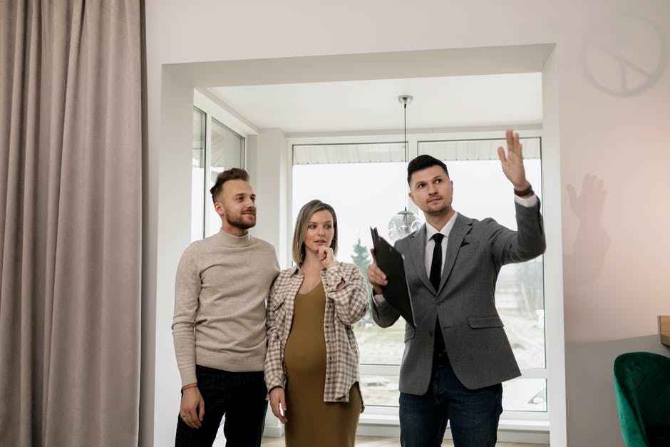 Real Estate Agent showing a property to a couple of people