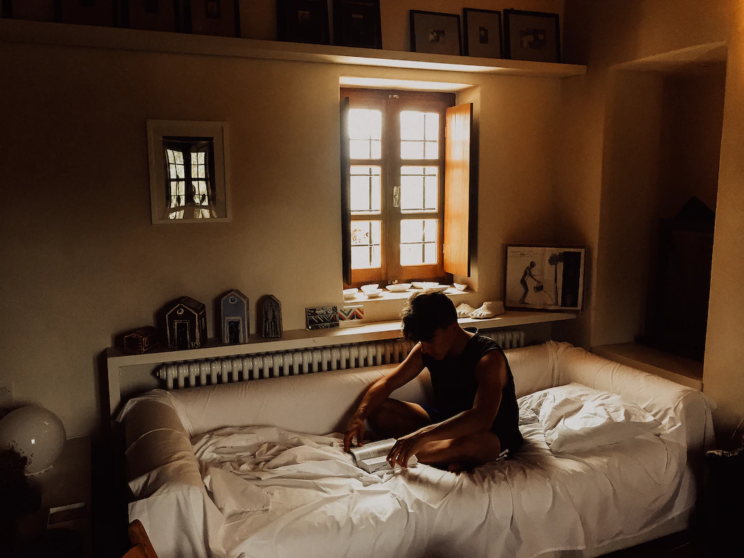 person sitting on a bed reading