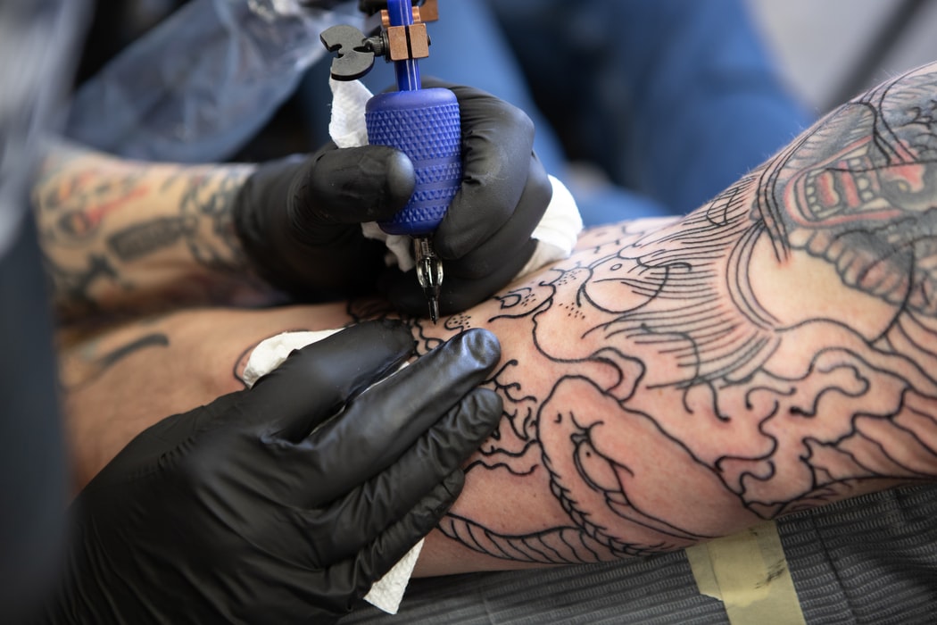 Person getting a tattoo on his arm