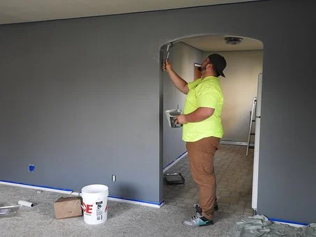 person painting a room grey