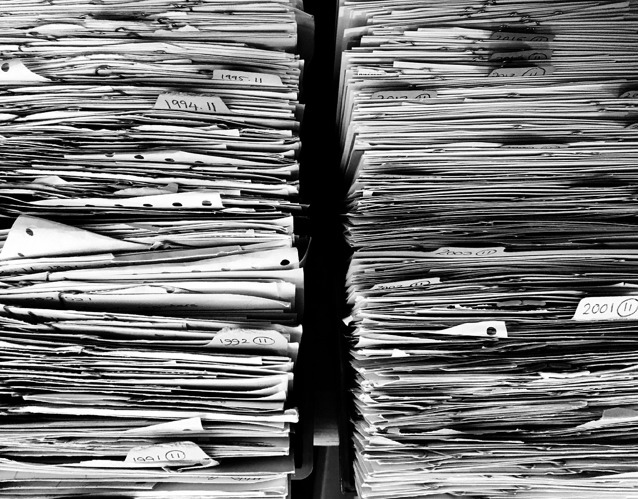 Two stacks of paperwork in files. Image by Pixabay