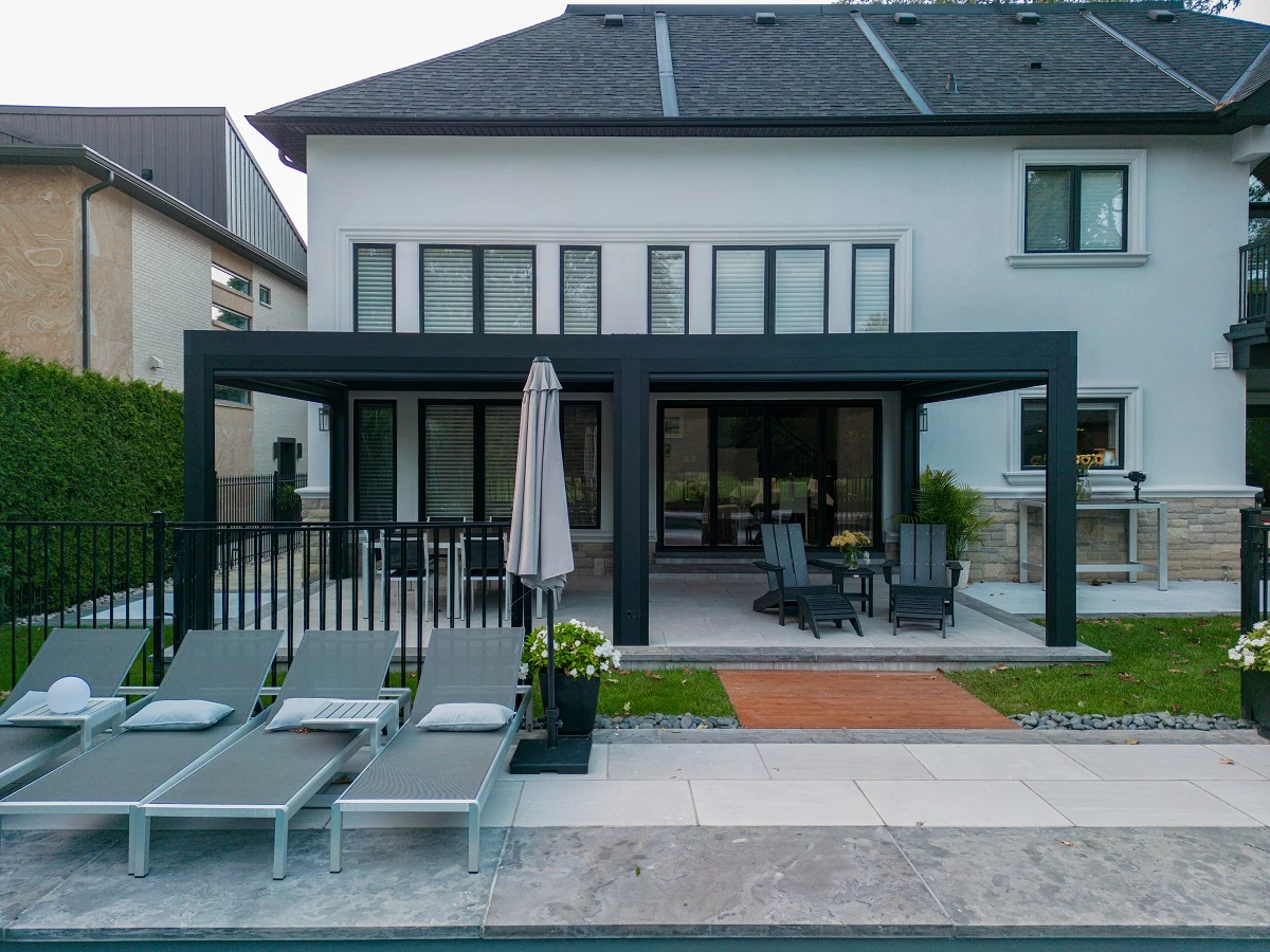 A white house with a laege patio, lawn chairs.