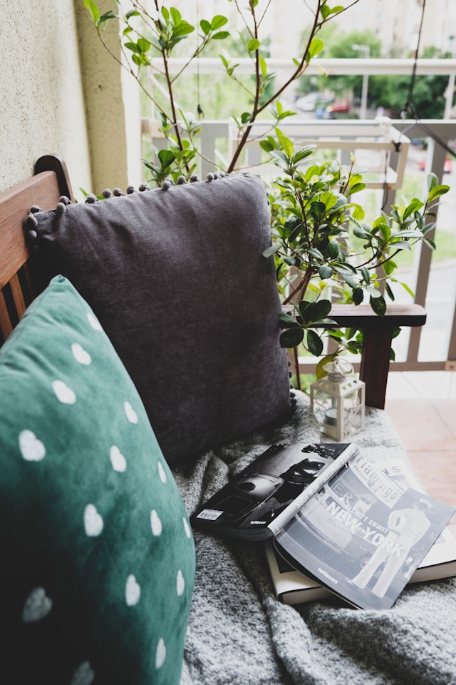 Cozy balcony with furniture, plants, and a book. Image by Unsplash
