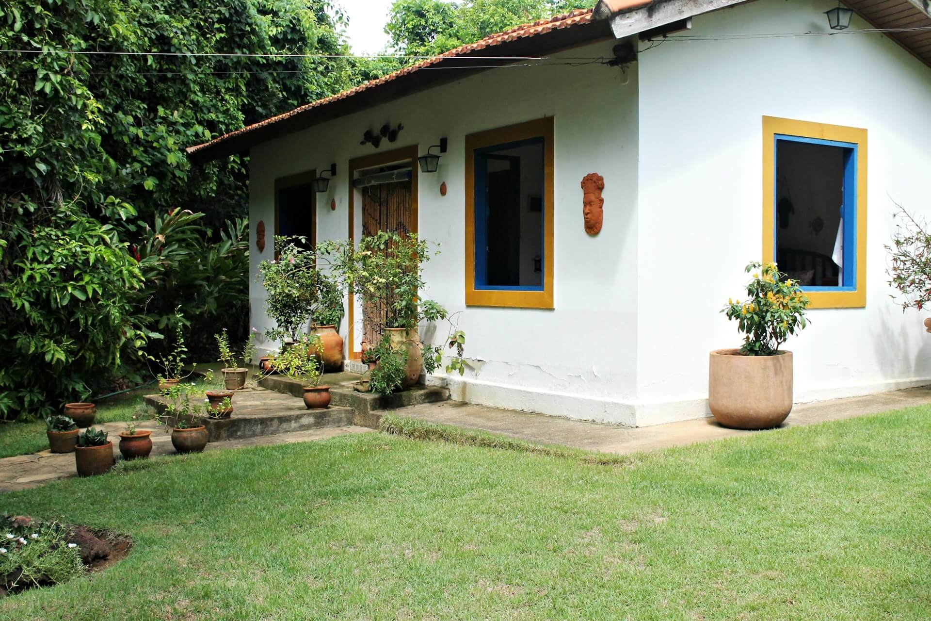 White concfrete house beside green leafted trees. Image by Unsplash