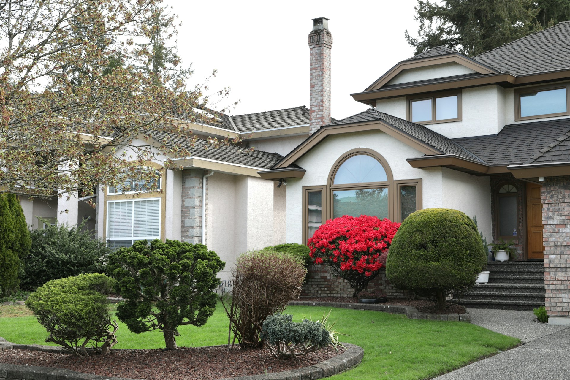 Healthy green front lawn of a suburban rental house with a clean walkway. Photo by QY Liu on Unsplash