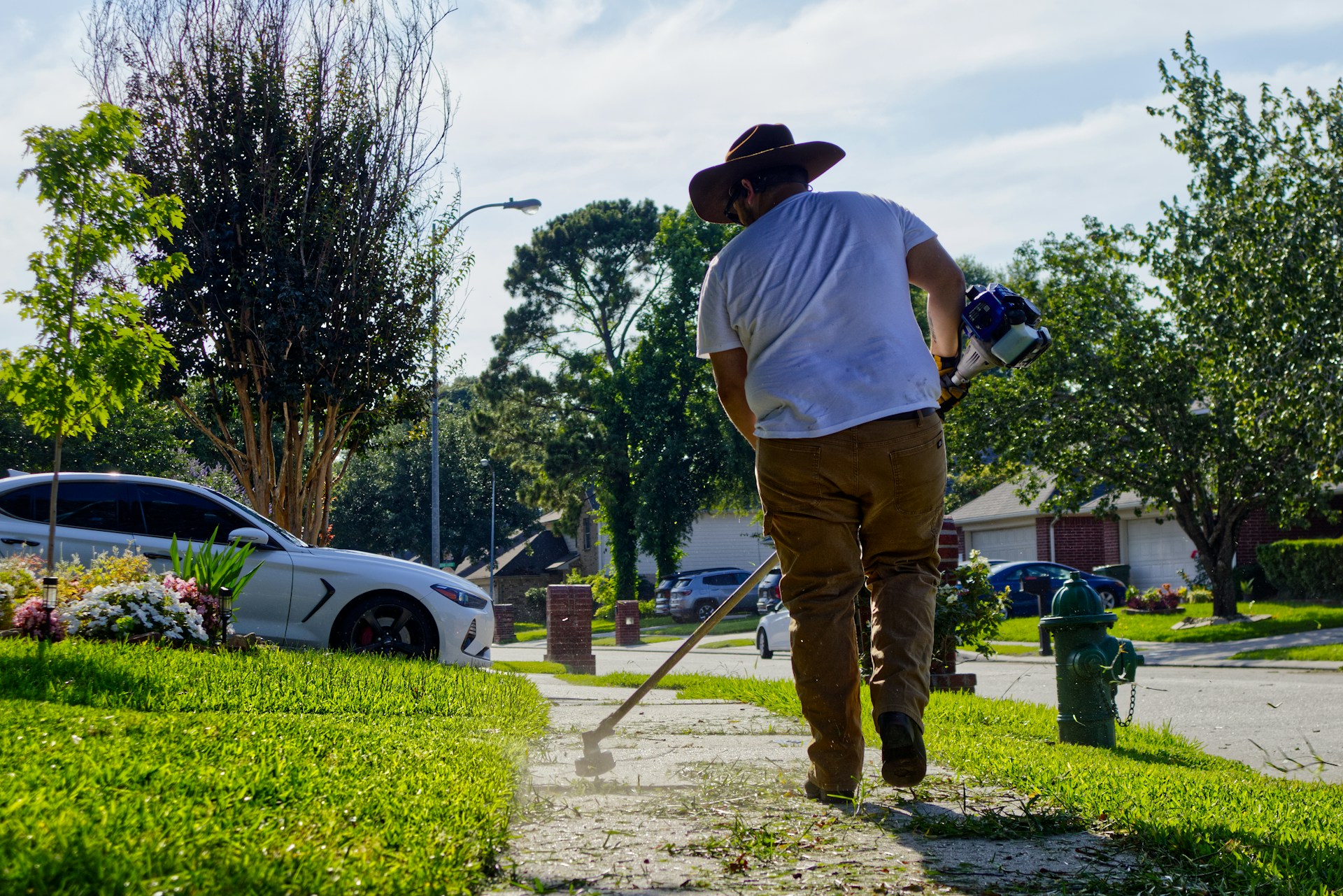 Person spreading granular lawn fertilizer with a broadcast spreader on a yard. Photo by Kenny Perez on Unsplash