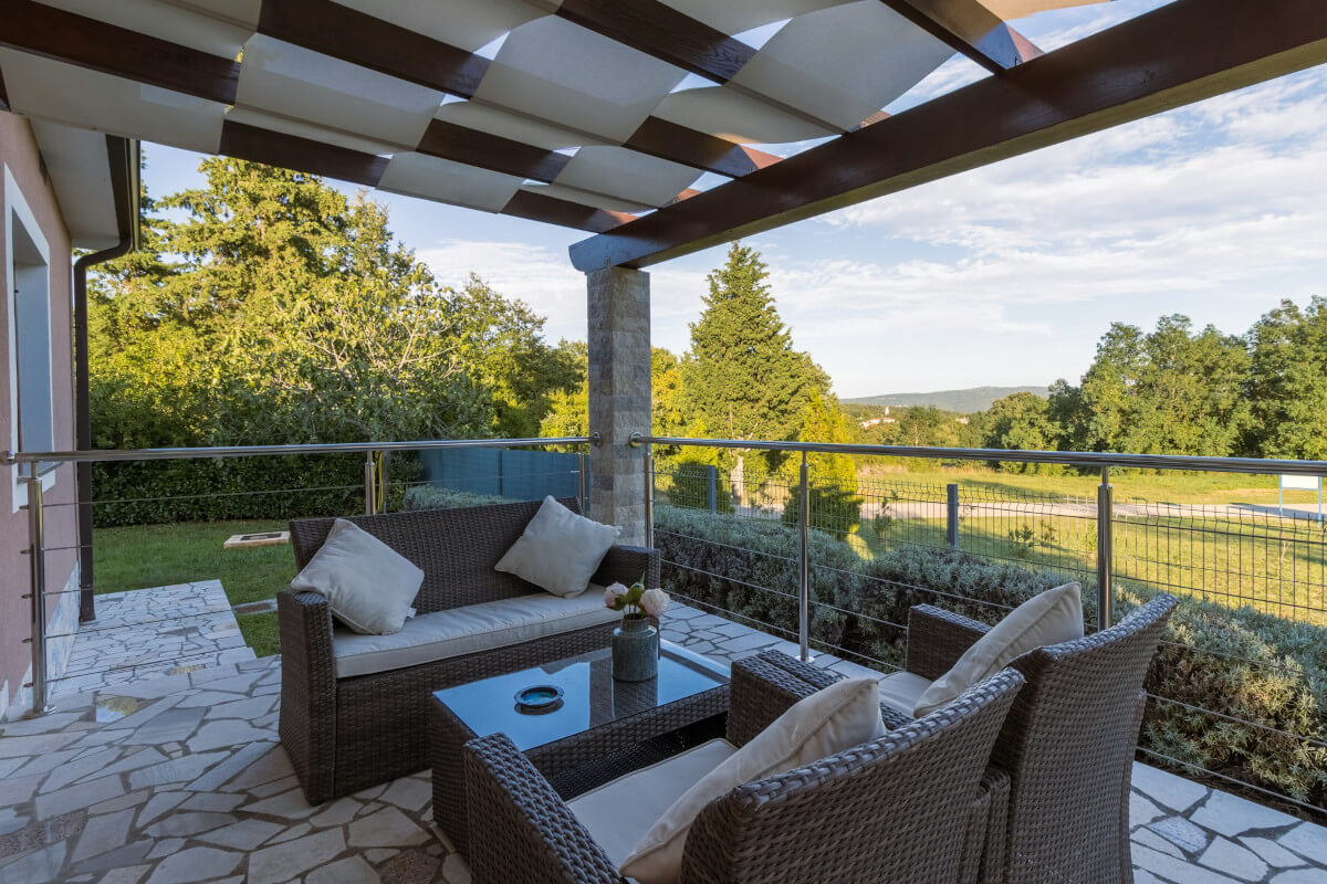 patio with brown wicker chair and table. Image by Unsplash