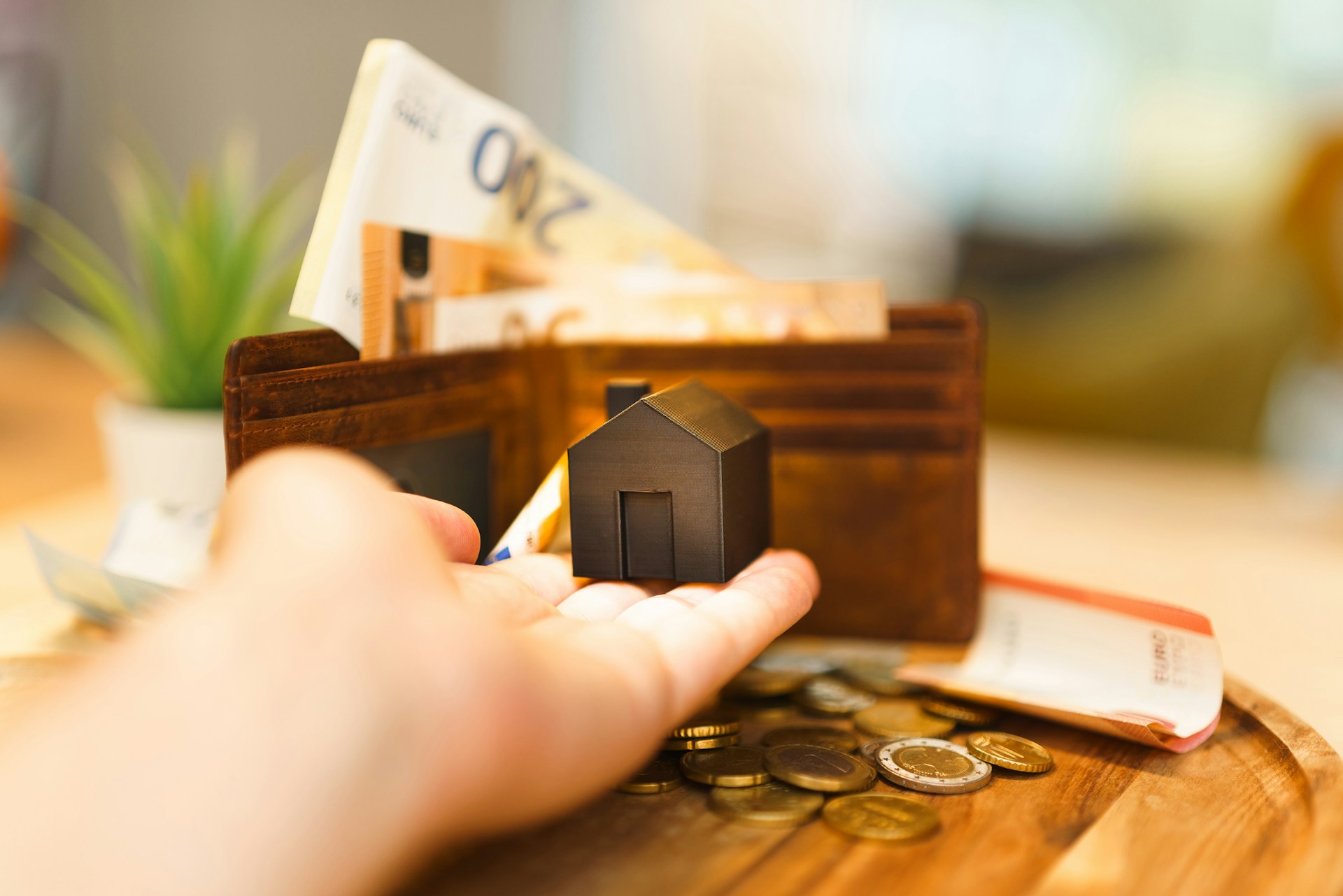 person in with a suit and purple tie, holding a house in his hand. Image by Unsplash
