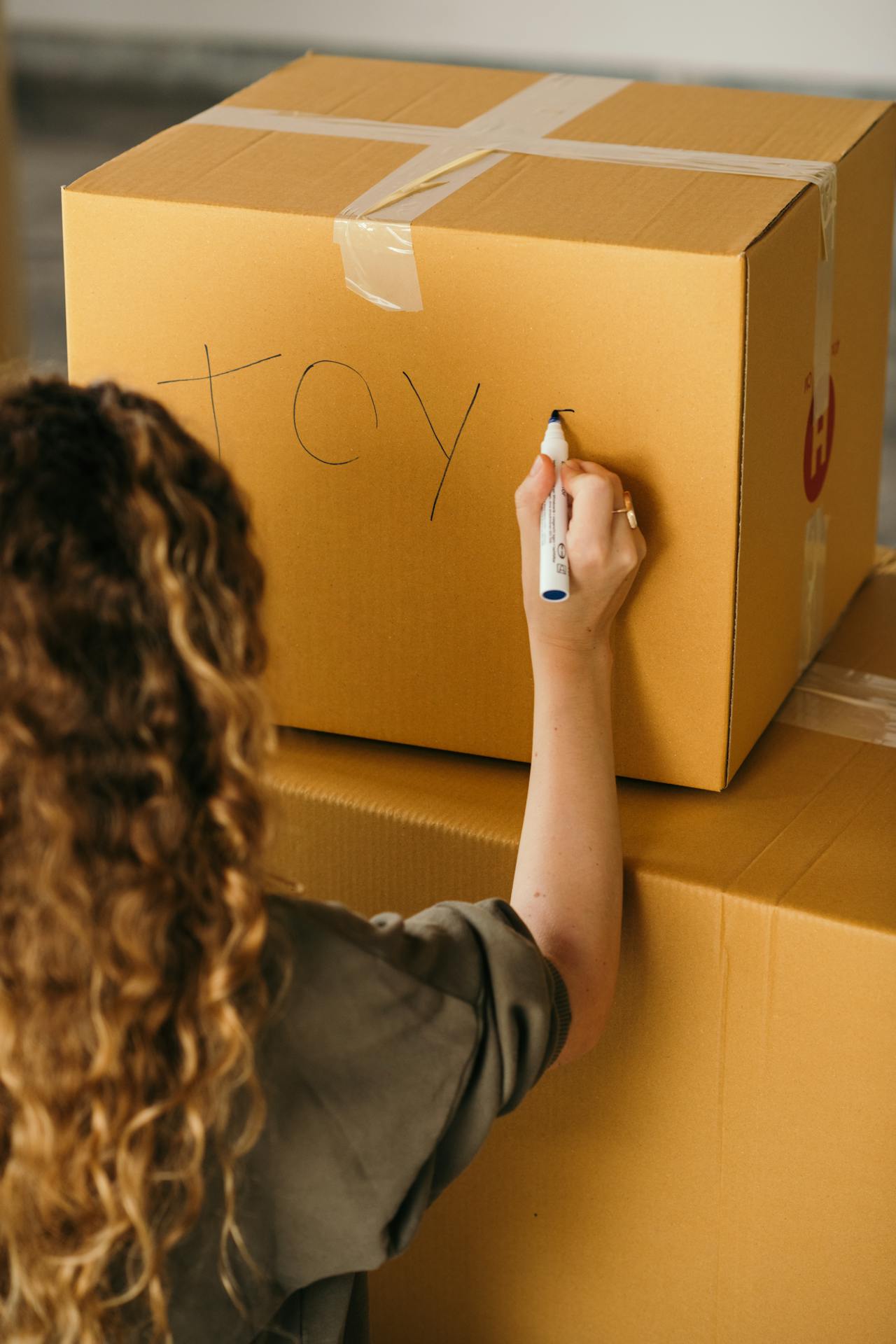 Person labeling a box. Image by Pexels