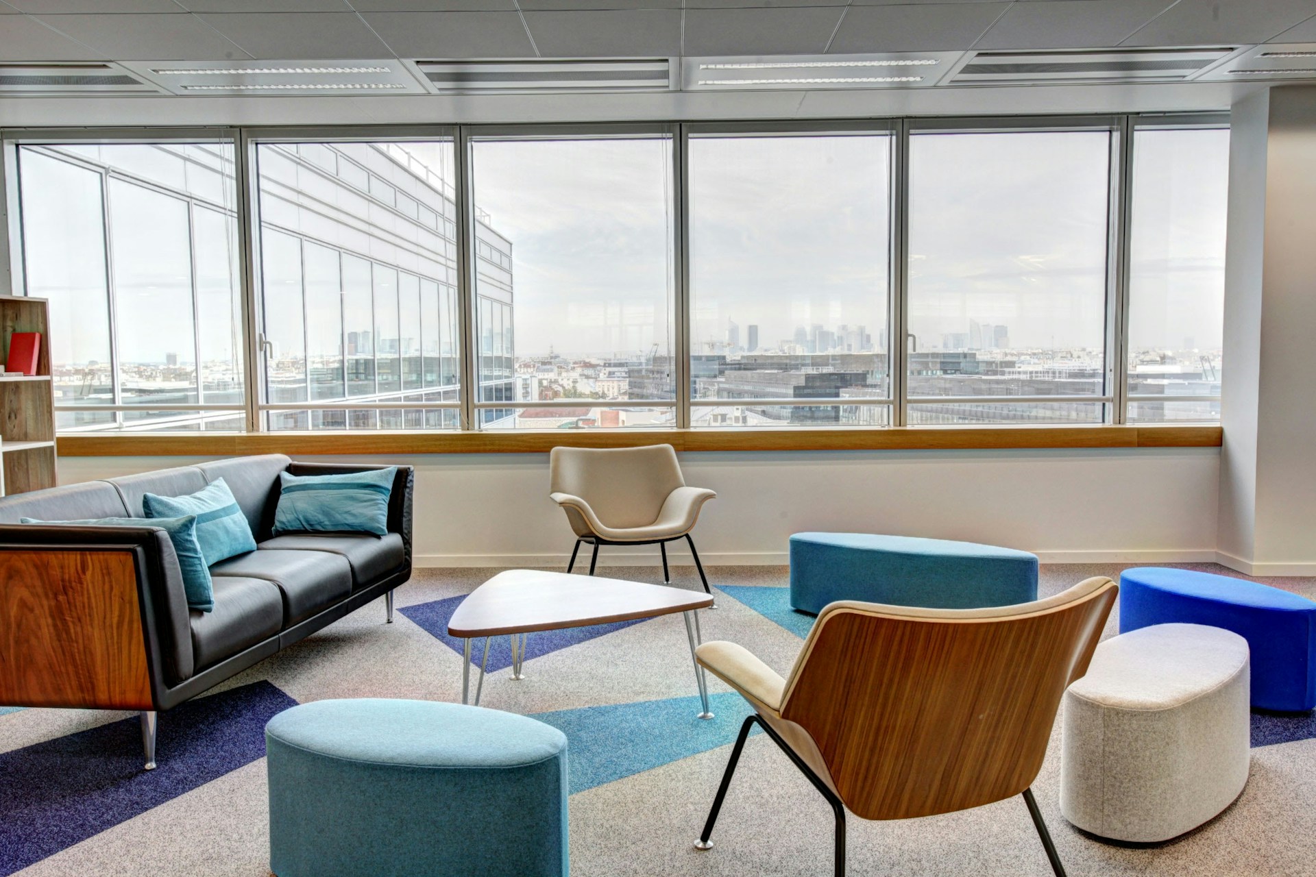 Oval brown wooden conference table and chairs in a conference room. Lots of floor to ceiling windows. Image by Unsplash