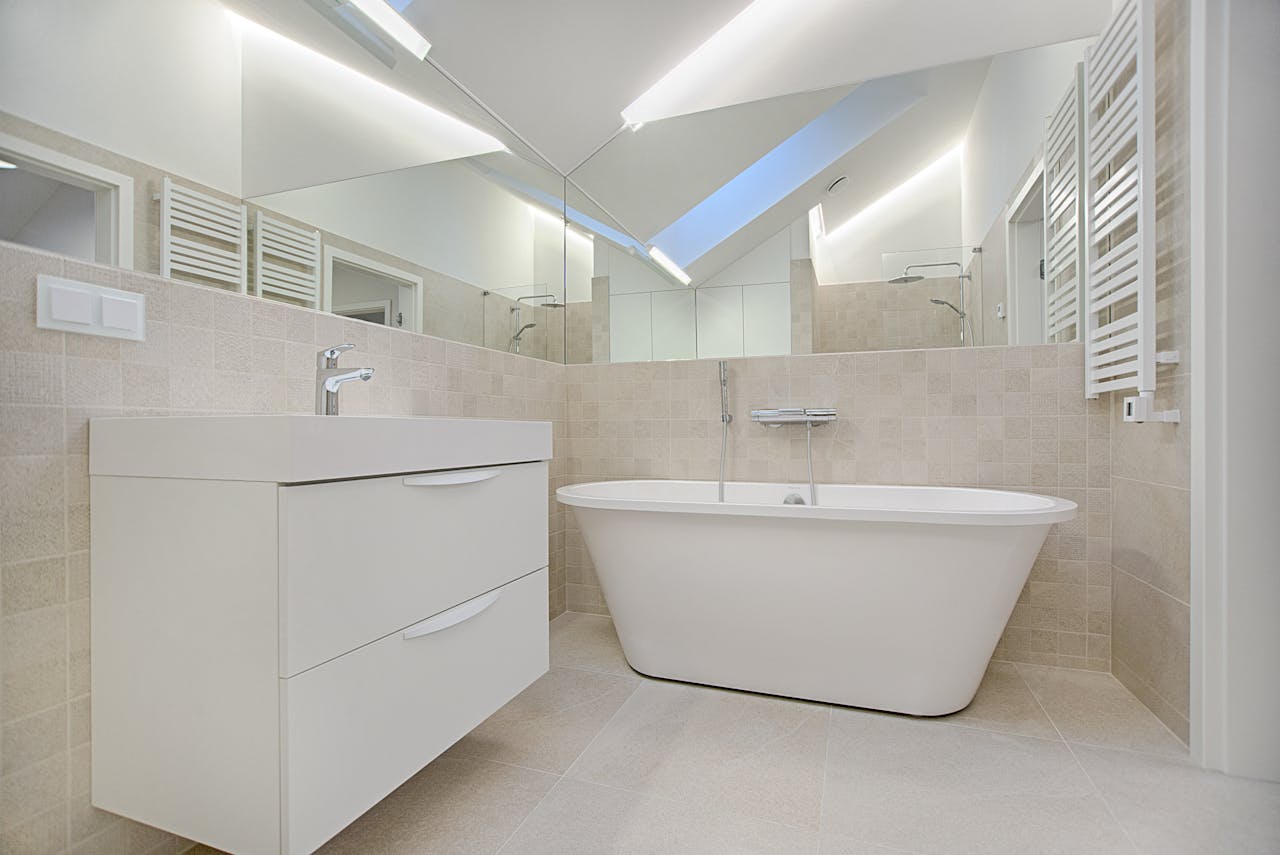 White bathtub and cabinet in a bathroom. Image by Pexels