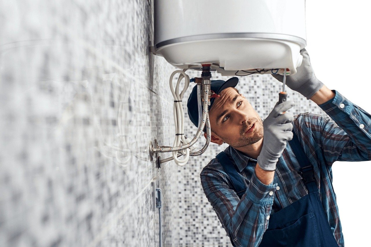 Plumber under a sink. Image by Pixabay