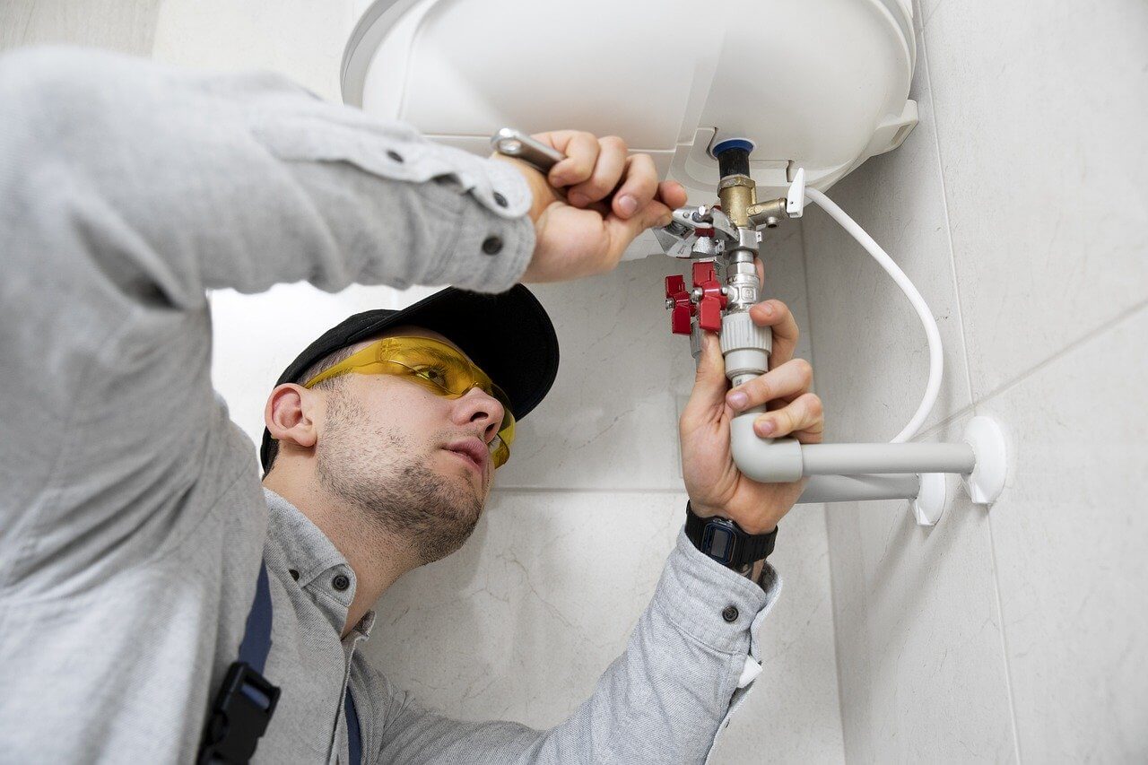 plumber doing a repair. Image by Pixabay