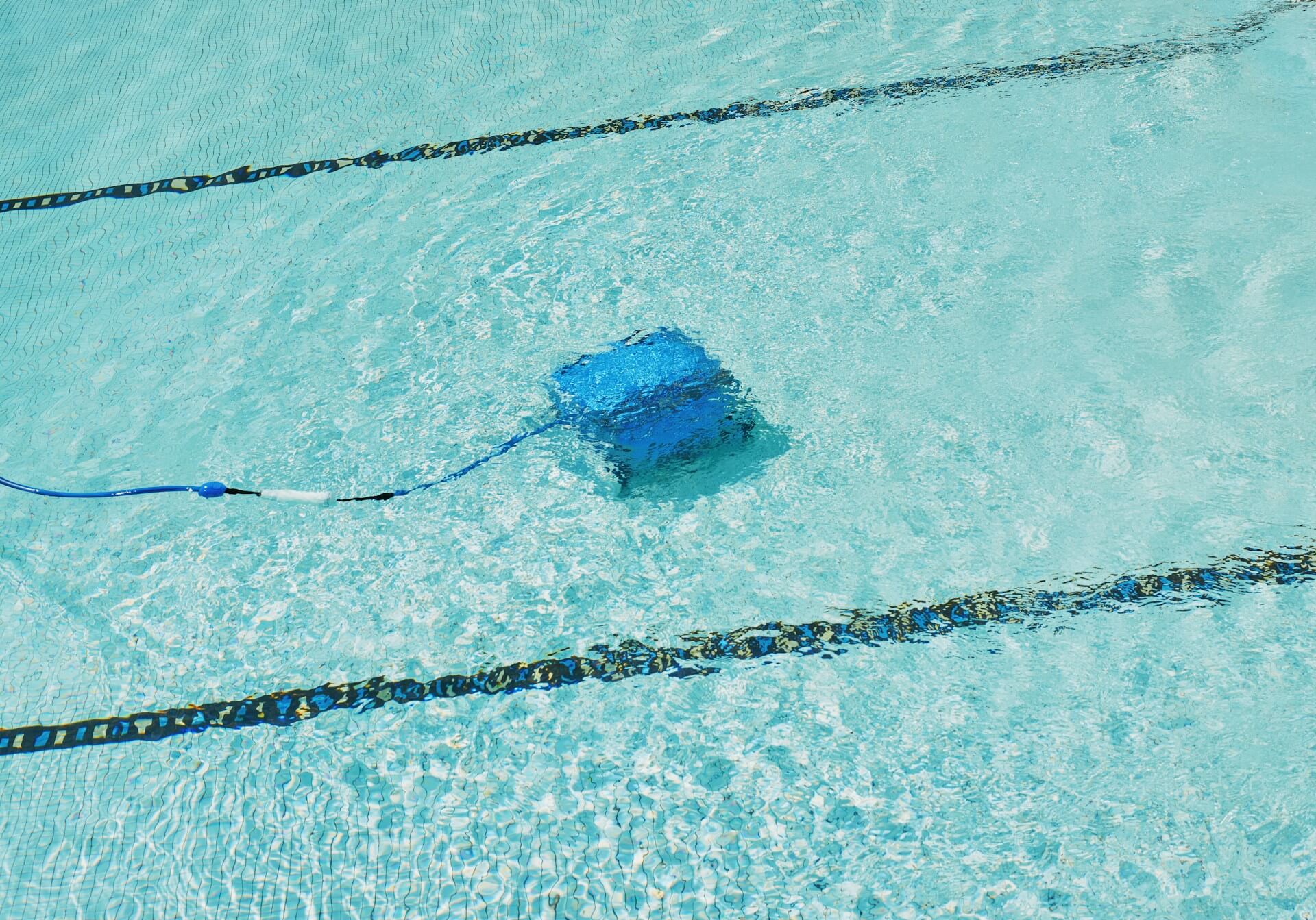 A person testing swimming pool water level. Photo by Zhiqiang Wang on Unsplash