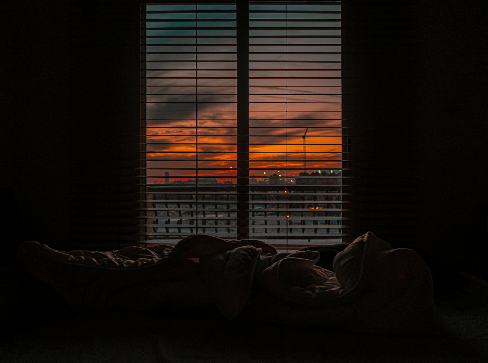 Sunset, sunrise, dark room with a bed