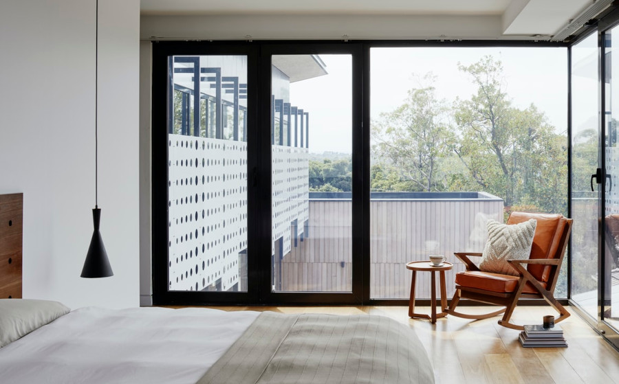 Bedroom with large windows and a door to go outside to a porch, rockingchair