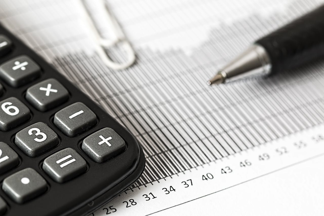 Calculator and a pen on a table. Image by Pexels