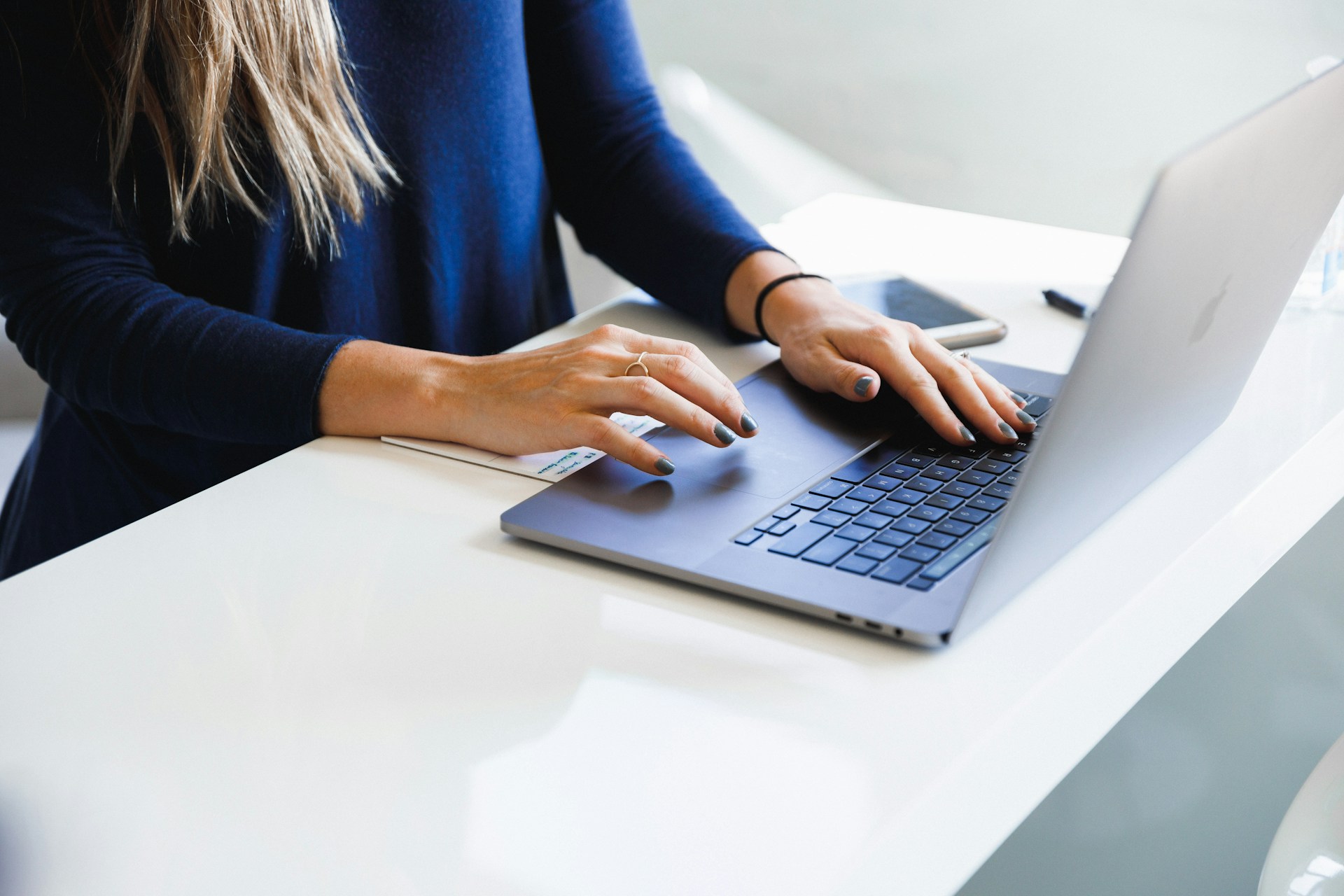 Person in a blue longsleeved shirt using a laptop. Image by Unsplash