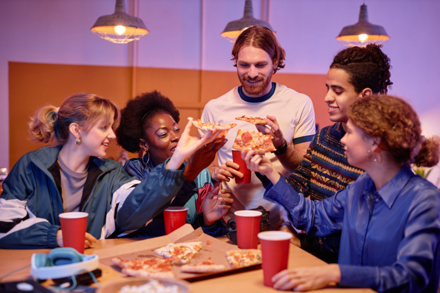 people sitting at a table eating pizza