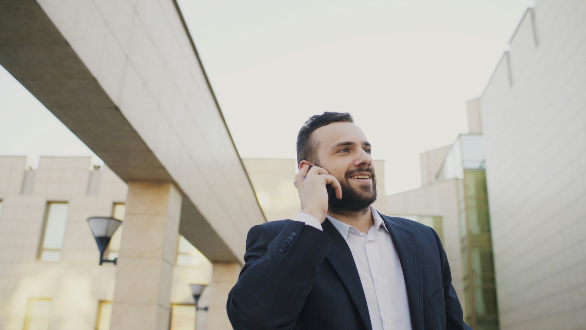 Person in suit talking on a cell phone outdoors. Image by Unsplash