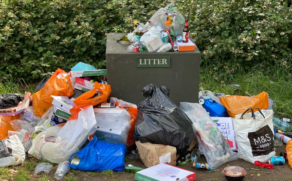 Garbage outside of a dumpster