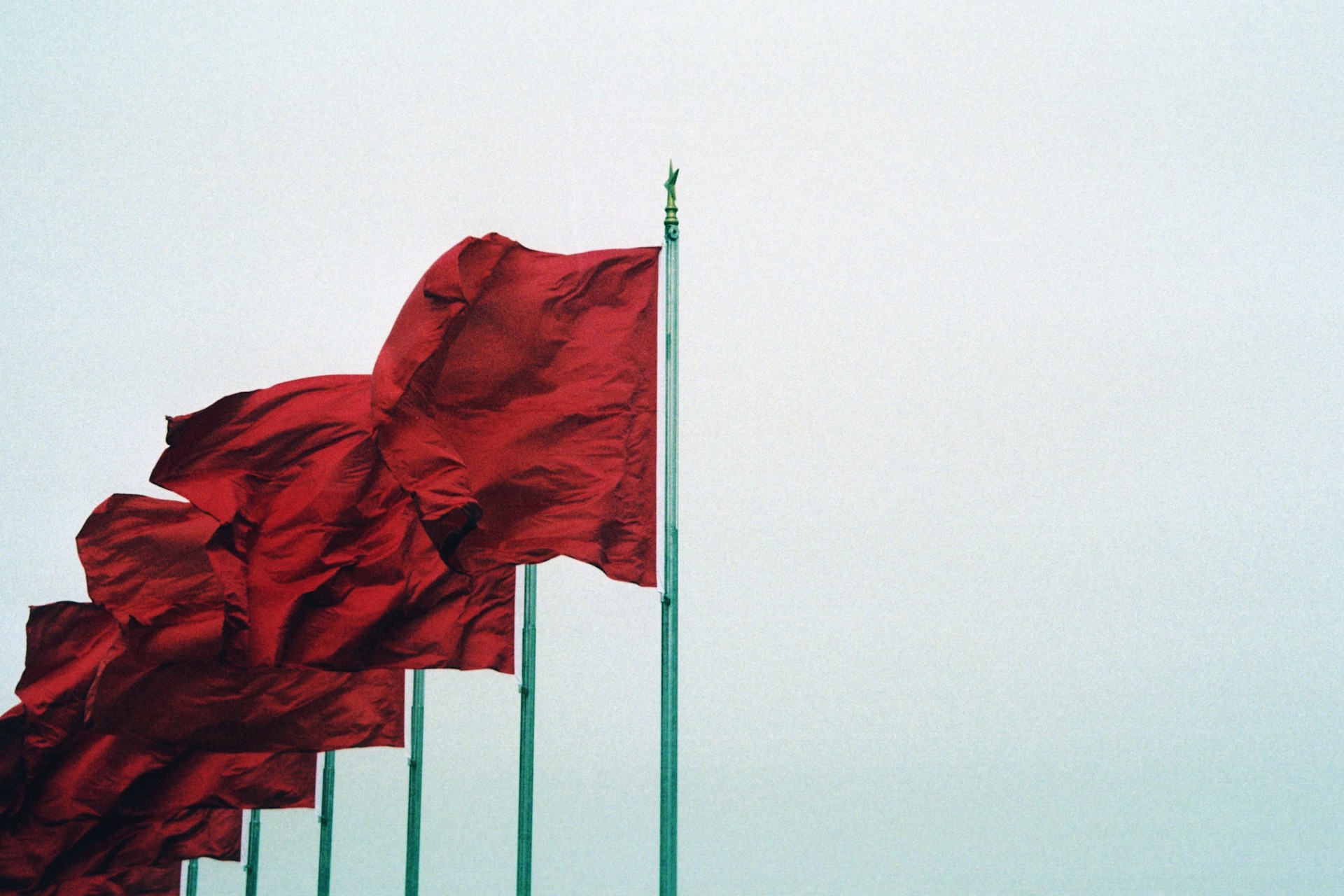 Red flags swinging in the wind. Image by Unsplash