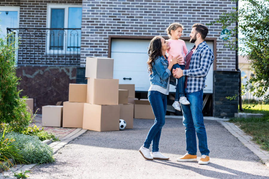 Family in front of a house, lots of boxes