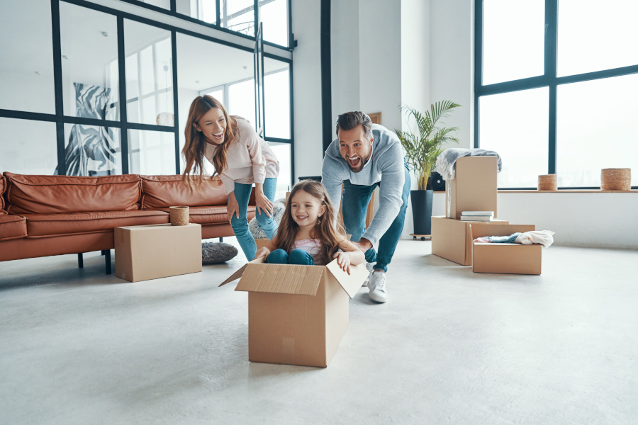family in livingroom, dad pushing daughter in a box