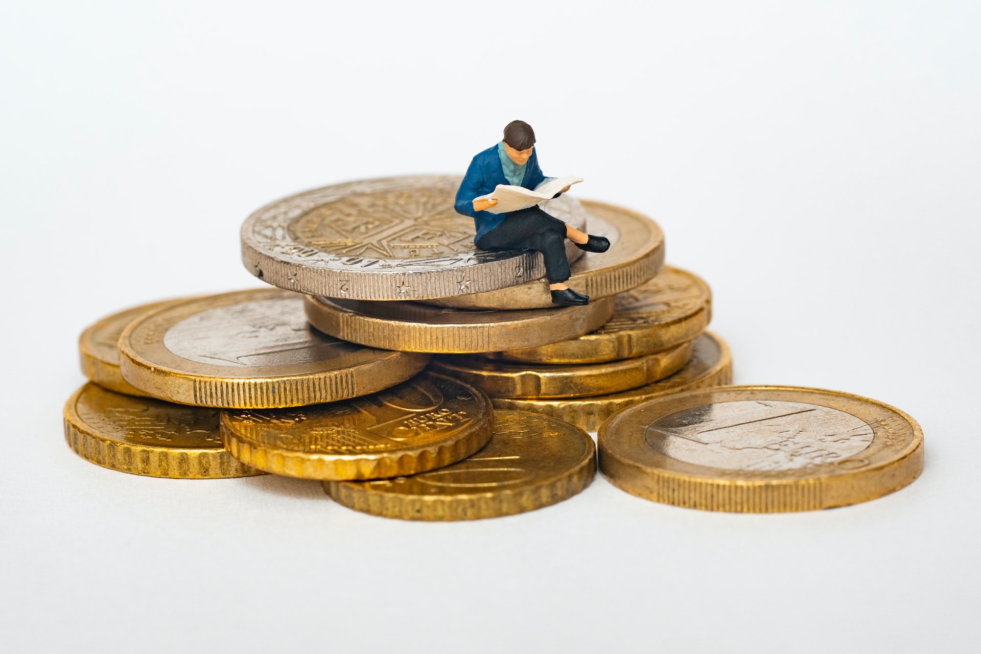 person sitting on large gold coins