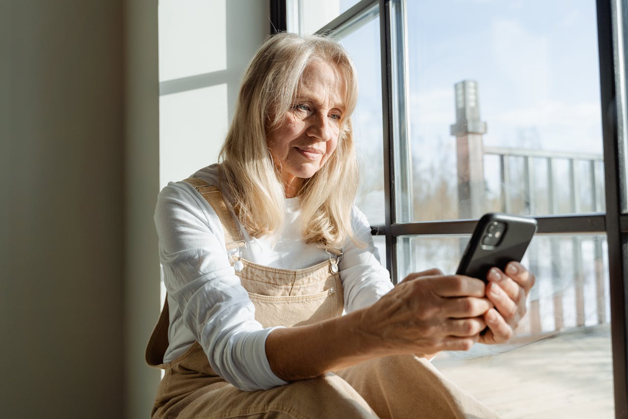 Person in a white shirt holding a cellphone. Image by Pexels